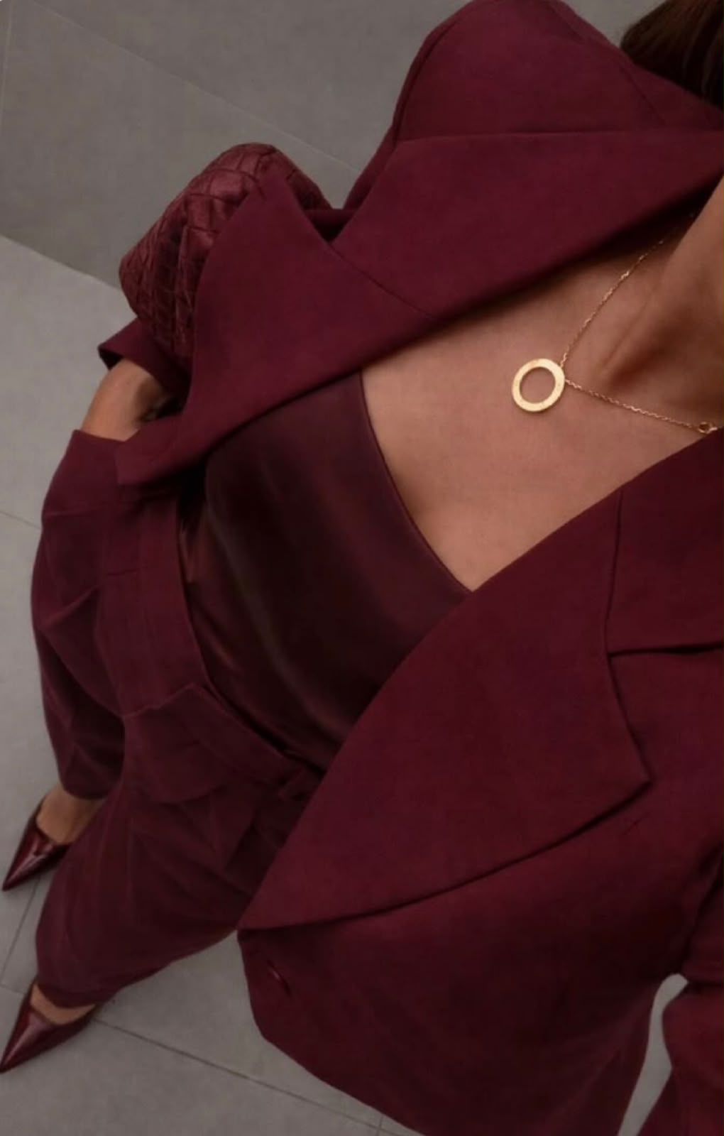A burgundy tailored suit with gold jewellery, echoing the Mondays Content Co palette